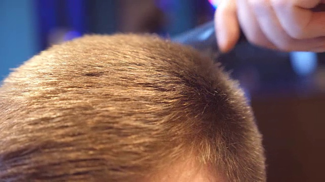 一个年轻人在理发店里给他的男顾客理发。弄头发的过程。顶部视图视频下载