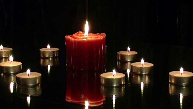 许多美丽的蜡烛在黑暗中燃烧着反射视频下载
