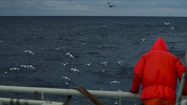 在暴風雨的海面上，漁民在漁船的甲板上視頻下載
