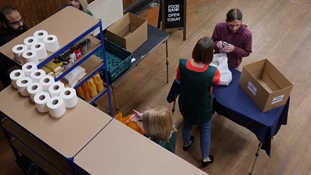 4K天线:一名男子将装满杂货/食物的袋子捐赠给食品银行视频素材
