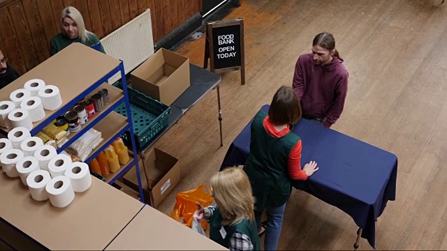 4K天线:一名男子在食品银行收到装满杂货/食物的袋子视频素材