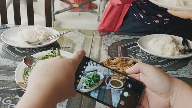 一名泰国男子在午餐前用智能手机给餐厅里的食物拍照视频素材