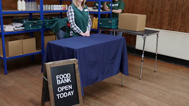 4K:一名妇女在慈善食品银行收到满满一袋食品视频素材