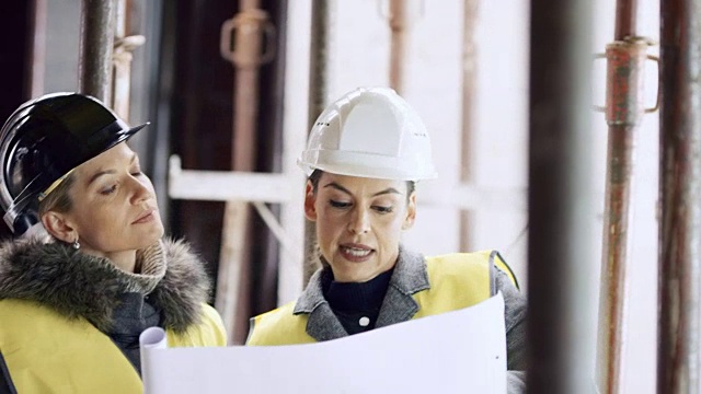 女建筑师在施工现场向女投资者解释方案细节视频素材