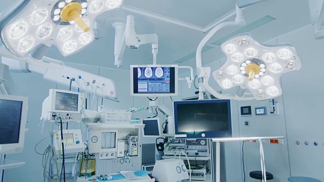 拍攝技術先進的手術室，沒有人，準備手術。擁有工作設備、燈光和電腦的真正現代手術室為外科醫生和病人準備好了。視頻素材
