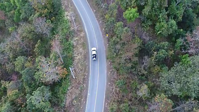 空中拍摄的汽车驾驶通过森林道路无人机旅行乡村冒险视频素材