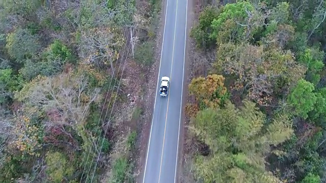 空中拍摄的汽车驾驶通过森林道路无人机旅行乡村冒险视频素材