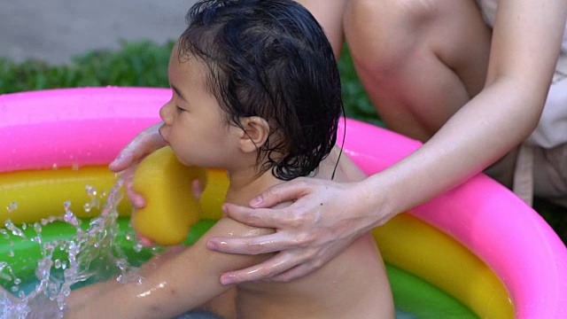 慢镜头拍摄亚洲小女孩和妈妈玩耍和洗澡。视频素材_ID:VCG42N963304360-VCG.COM 