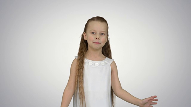 可爱的小女孩在白色的背景上唱歌跳舞视频下载