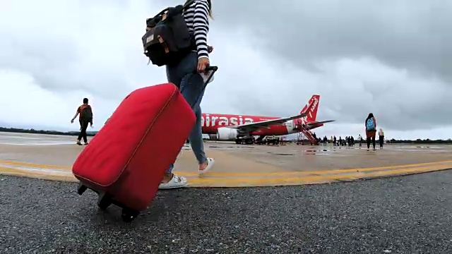 带着红色行李走向飞机的女性旅客视频素材