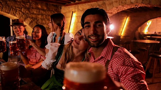 年轻的多民族朋友在传统的酒吧里喝着啤酒庆祝啤酒节视频素材