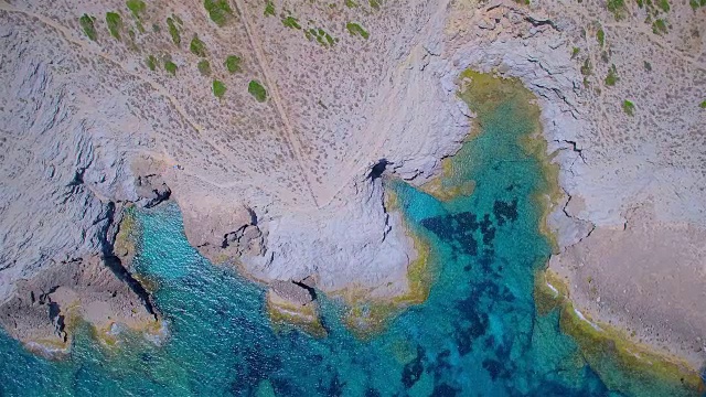 在西班牙马略卡岛的巴利阿里群岛东北海岸，Ses Maganetes朝向Cap de Ferrutx的小海湾Cala Estreta的正上方视频素材