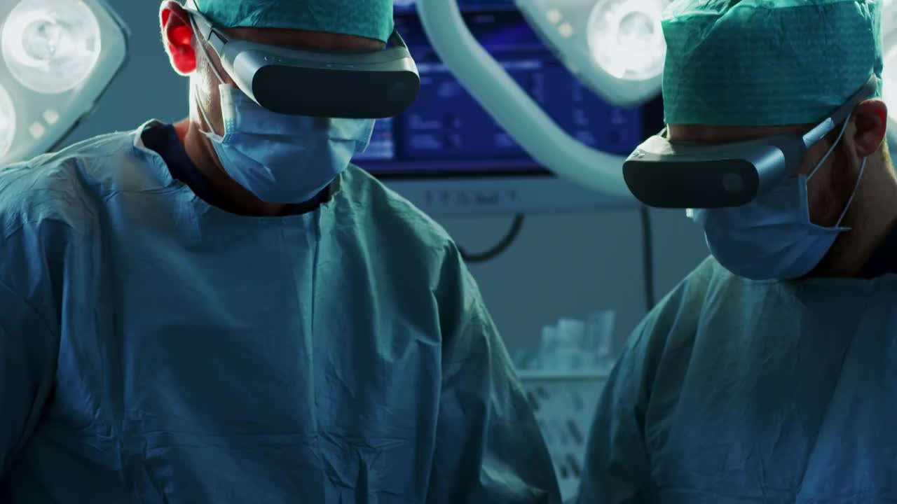 外科医生戴着增强现实眼镜在动画3D心脏模型的帮助下进行心脏手术。用手势做困难的心脏移植手术。互动动画显示生命体征。特写镜头。视频下载