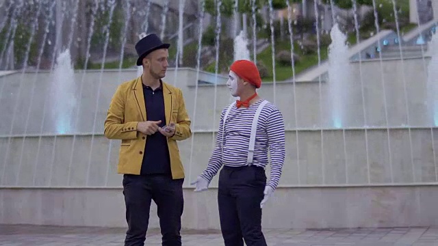 两个街头演员在城市广场的喷泉附近鬼混视频下载