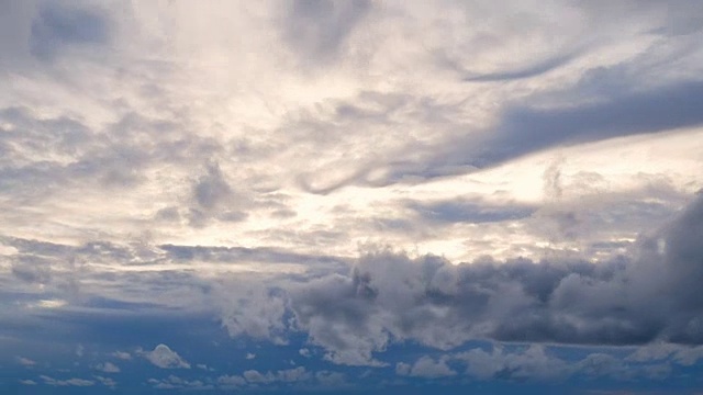 4K视频时间的白色蓬松蓬松的云快速移动蓝天与金色的光在日落或日出时间视频素材