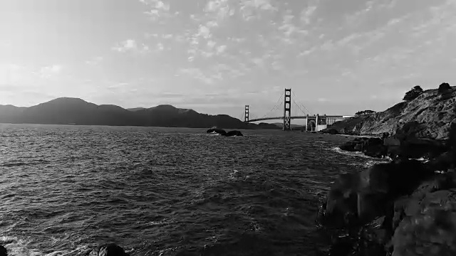 旧金山贝克的海滩无人机视图飞过岩石延伸到太平洋与金门大桥在背景视频素材