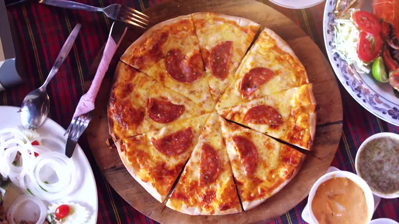 俯视图的一个披萨香肠和蔬菜沙拉，相机旋转。缓慢的运动。3840 x2160视频下载