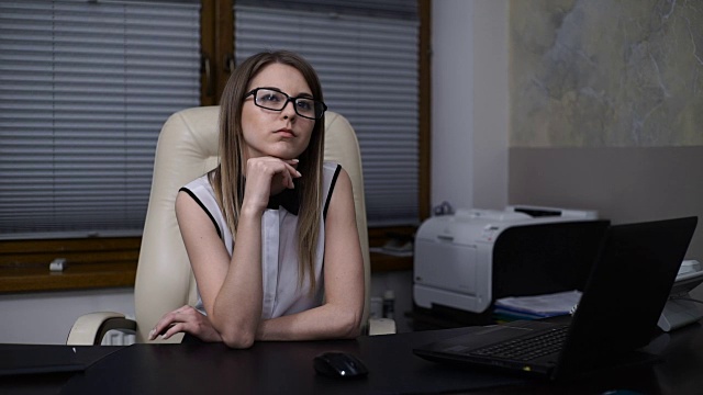 女秘书梦想在办公室工作。女孩坐在桌子边想视频下载