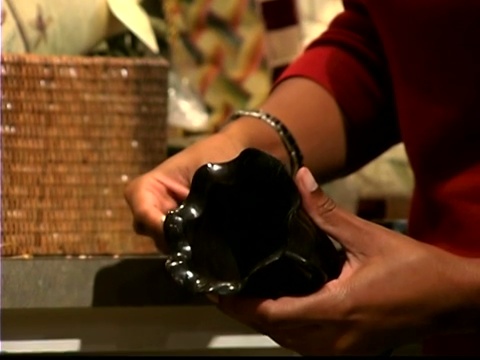 一个女人的手的特写，当她看一个花瓶和它的价格。视频下载