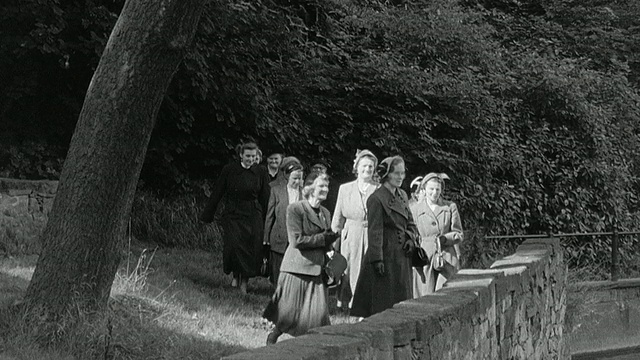 1956蒙太奇旅客离开火车站，沿着河岸散步/英国视频下载