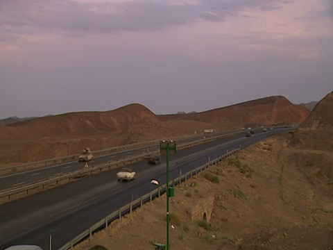 在伊朗庫姆沙漠沿線的高速公路系統上行駛的車輛視頻素材