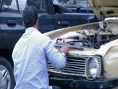ZI工人在一個店面停車場修理皮卡的格柵，而其他人正在觀看/德黑蘭，德黑蘭，伊爾恩視頻素材