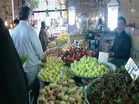 在伊朗德黑蘭的一個市場里，與顧客和小販一起走過一條狹窄的農產品通道視頻素材