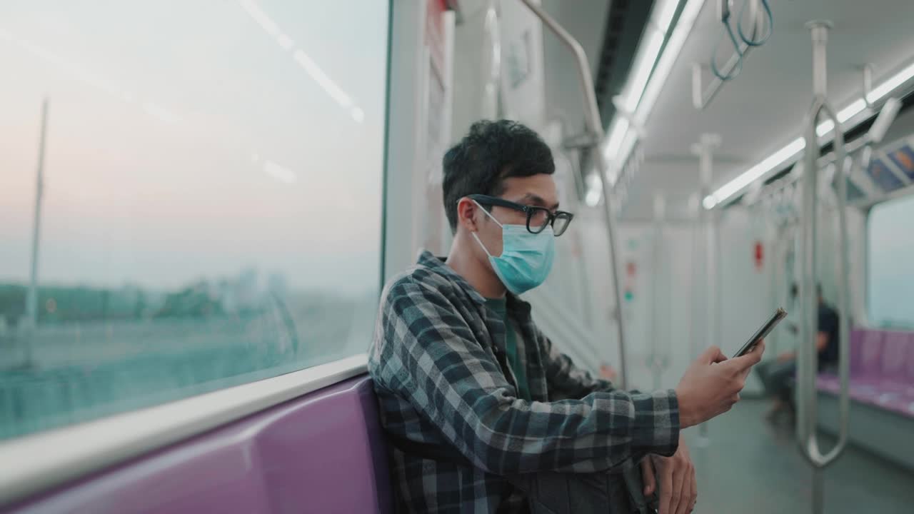一名男子在火车上用智能手机看风景视频下载