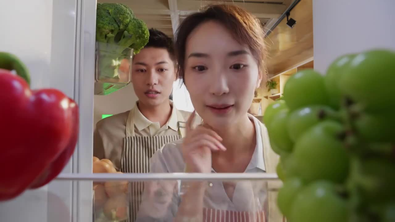 青年夫妻开冰箱拿食品视频素材