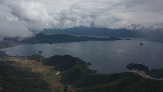 从格姆女神山上空的云雾中飞过俯瞰泸沽湖风光视频素材