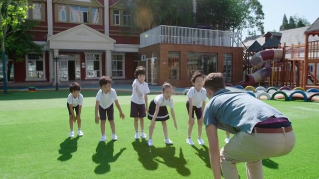 幼儿园老师和儿童在操场做体操视频素材