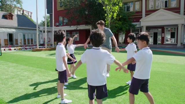 幼儿园外教和学生在操场玩耍视频素材
