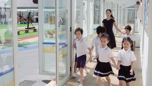 幼儿园老师和学生在学校走廊里视频下载