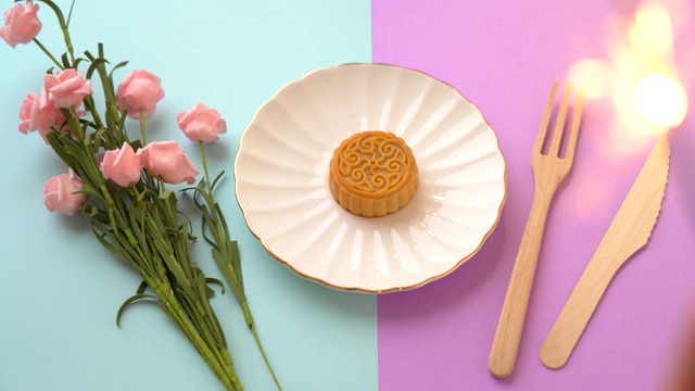 彩色背景上的花朵和托盘中央的小月饼视频素材
