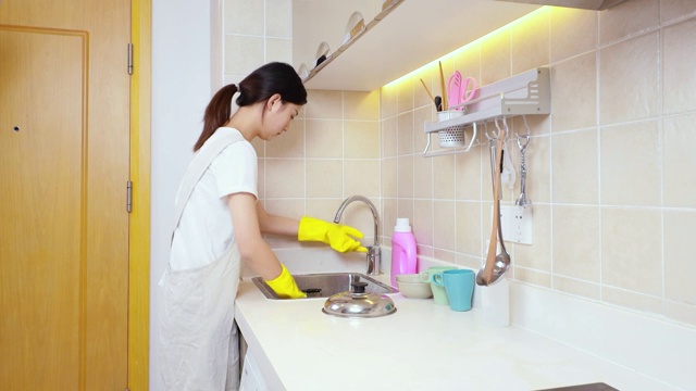 可爱的中国女孩，正在厨房洗锅视频素材
