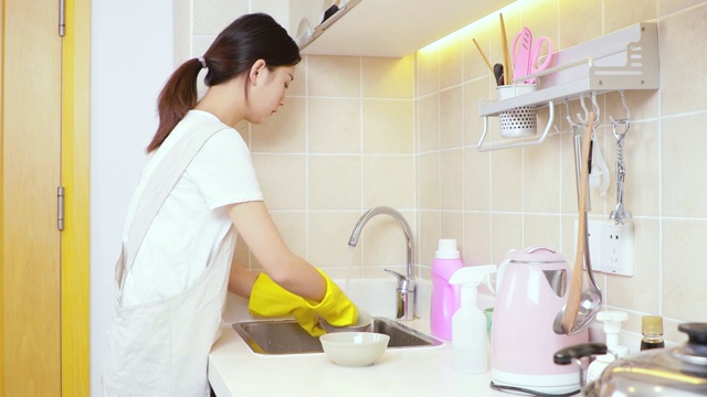可爱的中国女孩，正在厨房洗碗视频素材