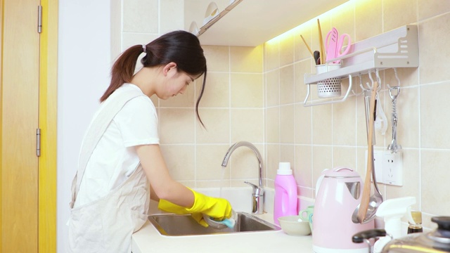 可爱的中国女孩，正在厨房洗碗视频素材