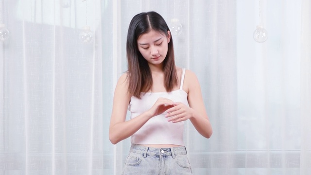 可爱的中国女孩，正在家里涂抹护手霜视频素材