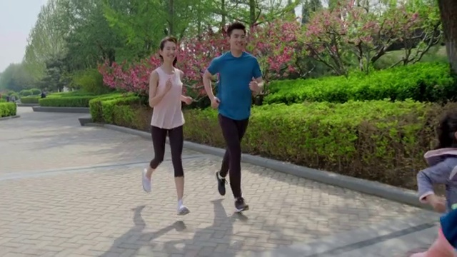 快乐的年轻家庭在公园跑步视频素材