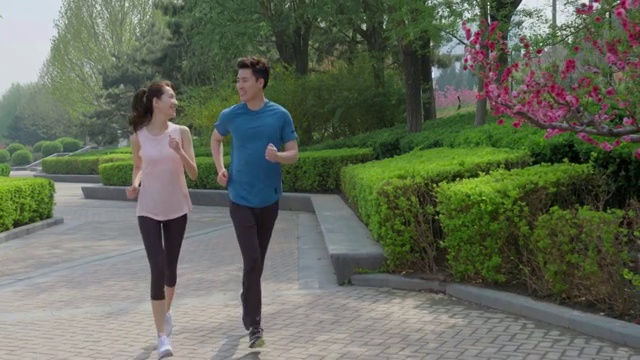 快乐的年轻情侣在公园跑步视频素材