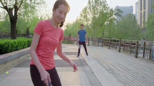 快乐的年轻情侣在公园打羽毛球视频素材