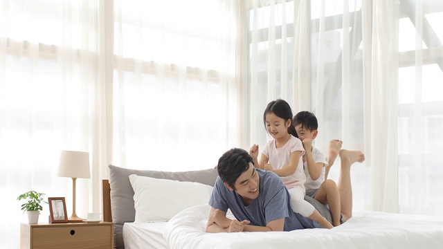 快乐的年轻家庭在卧室玩耍视频素材