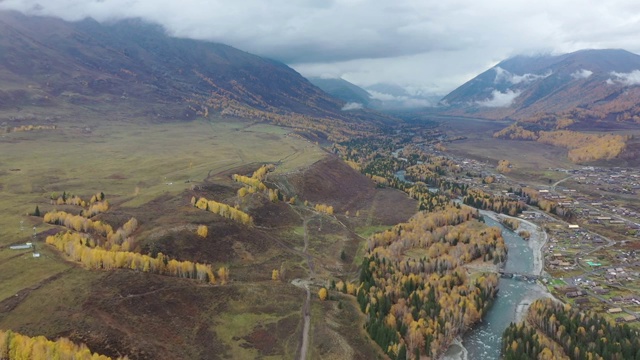 新疆阿勒泰布尔津县喀纳斯景区禾木乡村庄河流与烟雾秋季航拍视频素材
