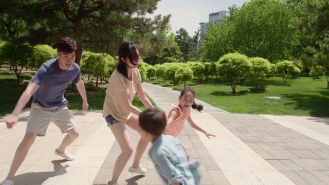 快乐的年轻家庭在公园玩耍视频购买