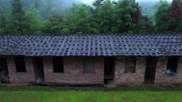 下雨天雨中宁静的绿色山村老房子屋檐雨滴听雨视频素材