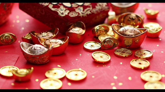 财源广进的旋转金币在推满金币及金元宝的春联上视频素材
