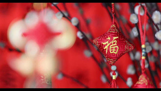 充满中国新年气氛的中国结及福字吊饰在闪亮闪亮的背景前视频素材