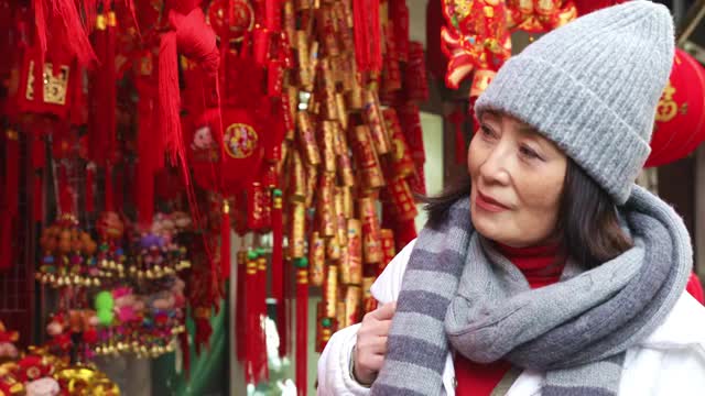 在上海豫园商店购买春节传统装饰物的女人视频素材