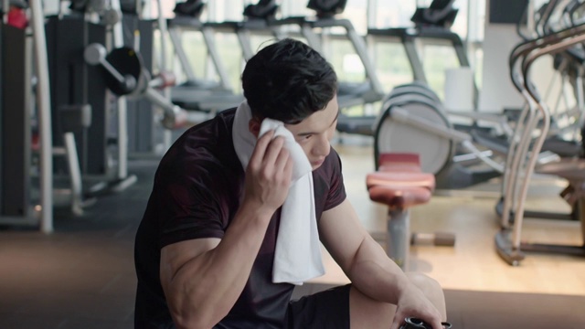 年轻男士在健身房健身后休息视频素材