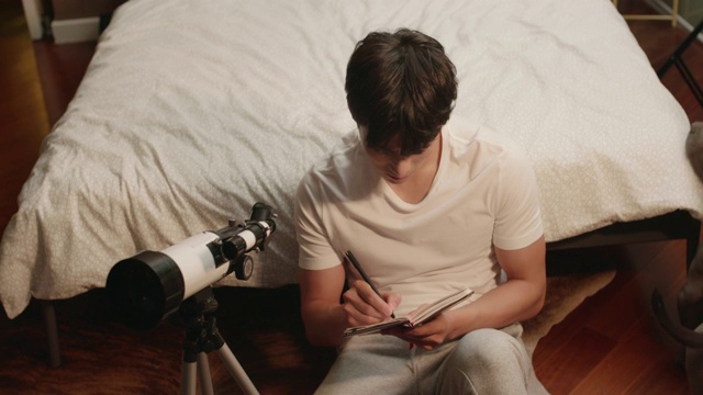 年轻男子在家使用望远镜视频素材